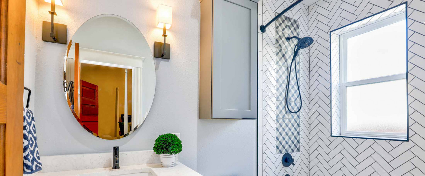 bathroom and shower remodel example with white tile shower and white marble countertop